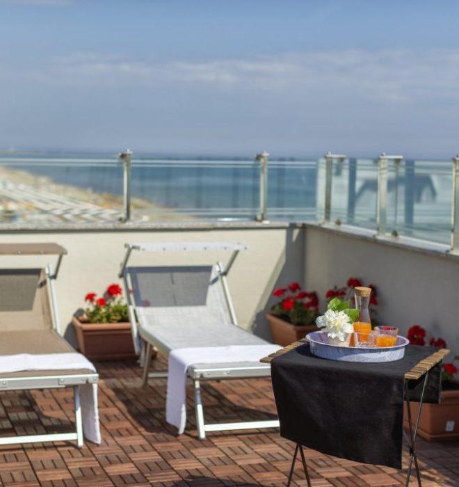 Terrazza con lettini, tavolino e vista mare.