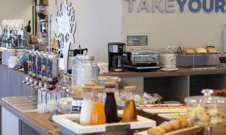 Buffet della colazione con succhi, dolci e pane.