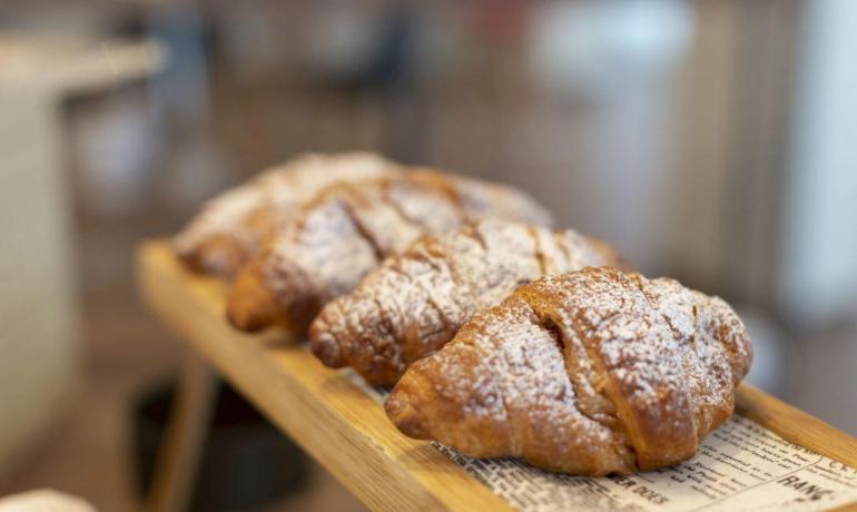 Croissant su vassoio di legno, spolverati di zucchero a velo.